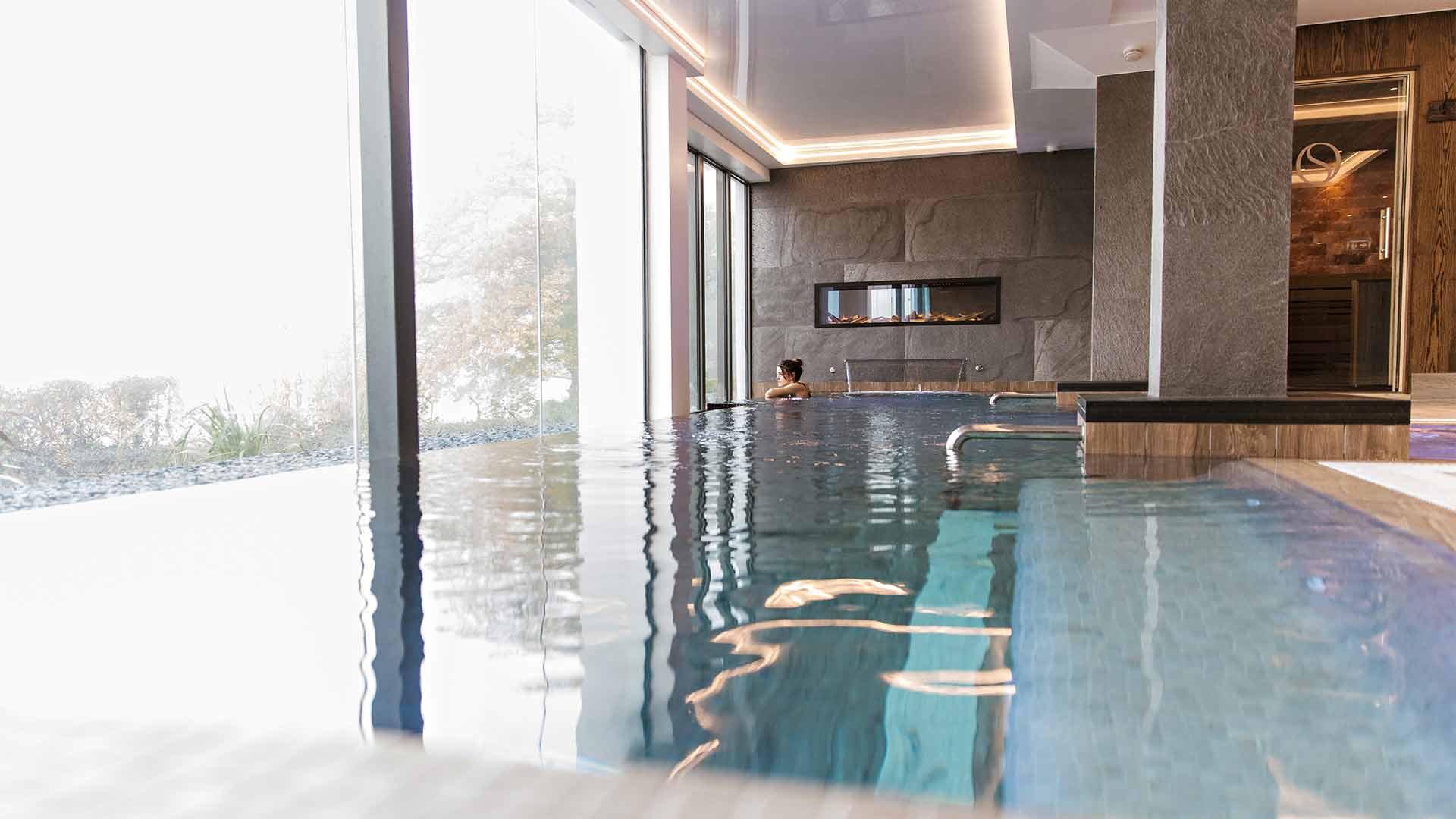 Young woman in the Spa's relaxation pool looking out over Windermere